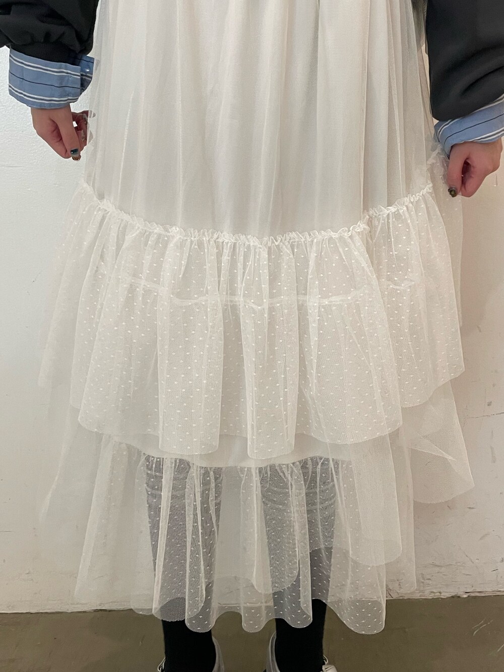 ホワイト系のスカート、ブラック系のスウェット、ブルー系のシャツ/ブラウスを着用したレディースの春コーディネートの7枚目の写真