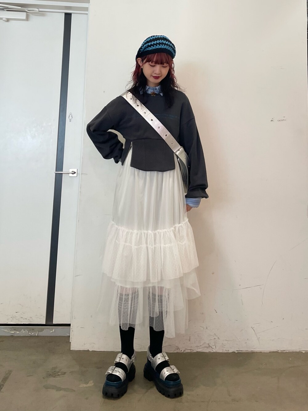 ホワイト系のスカート、ブラック系のスウェット、ブルー系のシャツ/ブラウスを着用したレディースの春コーディネートの2枚目の写真