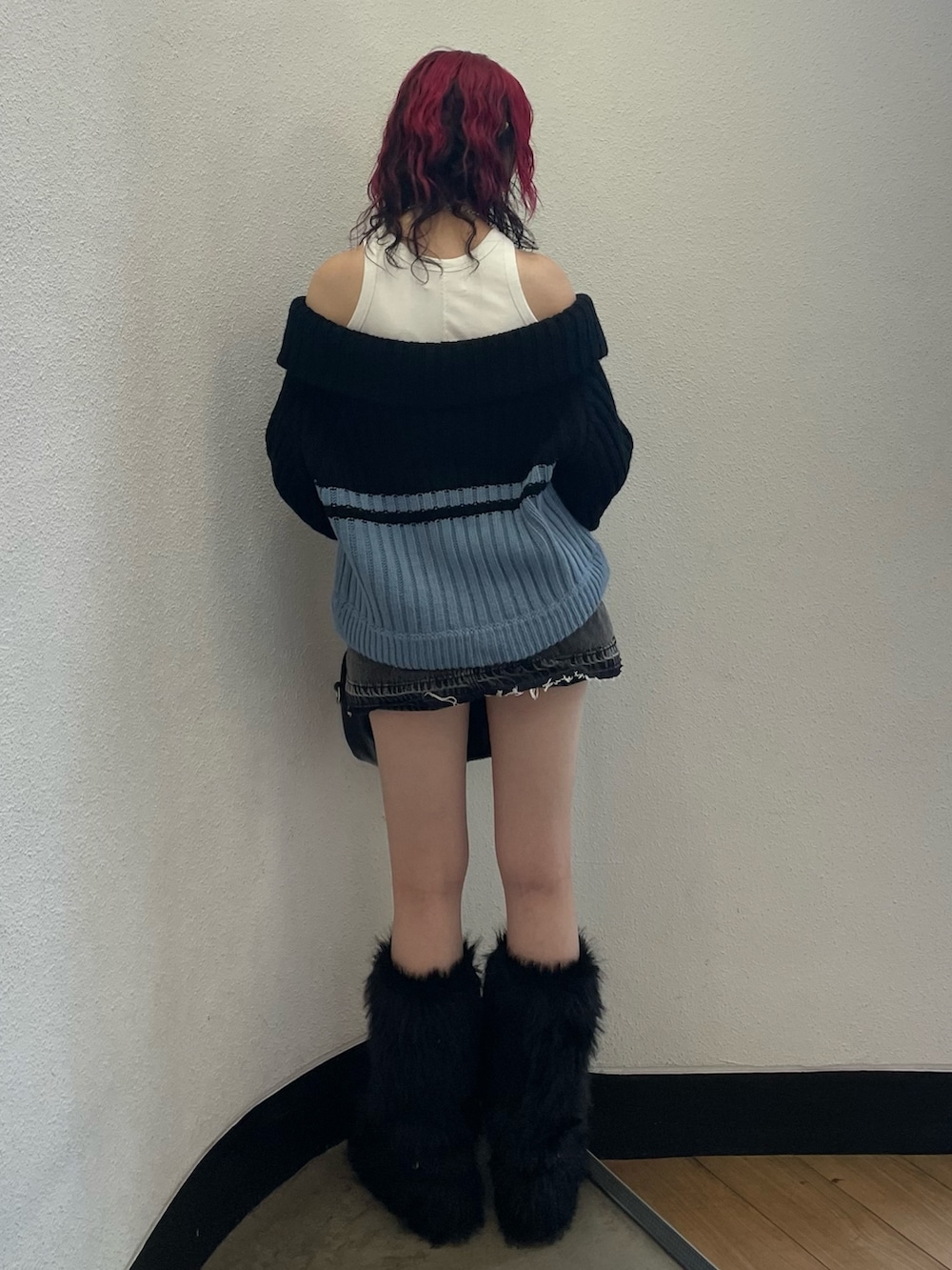 ブラック系のニット/セーター、ホワイト系のタンクトップ、ブラック系のデニムパンツを着用したレディースの秋コーディネートの3枚目の写真
