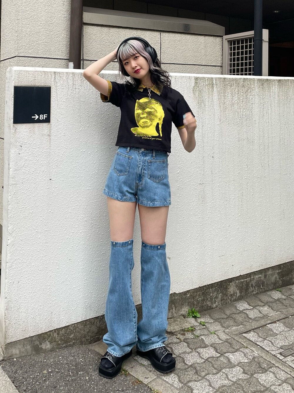 イエロー系のシャツ/ブラウス、ブラック系のTシャツ/カットソー、ブルー系のデニムパンツを着用したレディースの春コーディネートの2枚目の写真