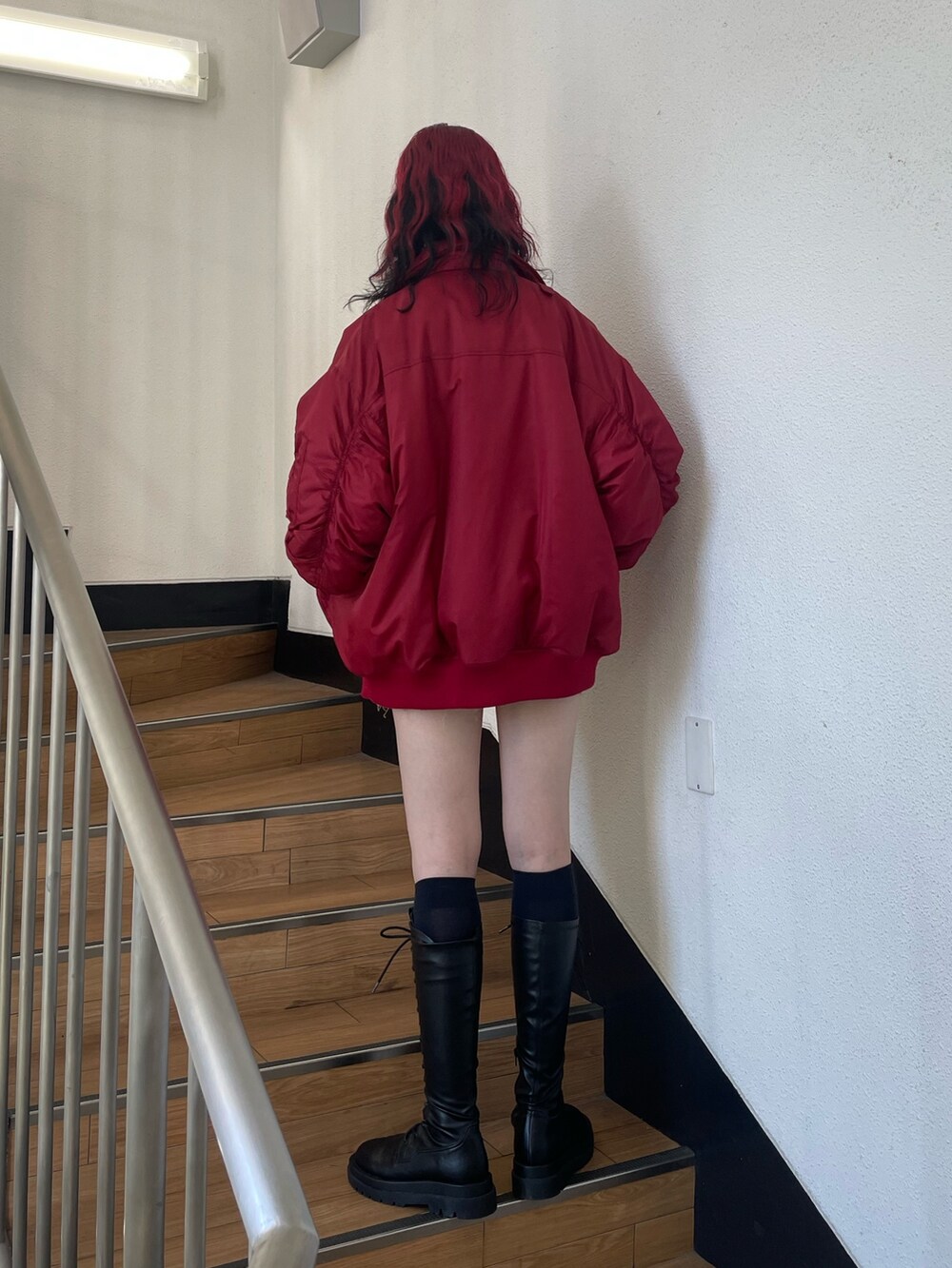 レッド系のMA-1、ホワイト系のシャツ/ブラウス、レッド系のネクタイを着用したレディースの秋コーディネートの3枚目の写真