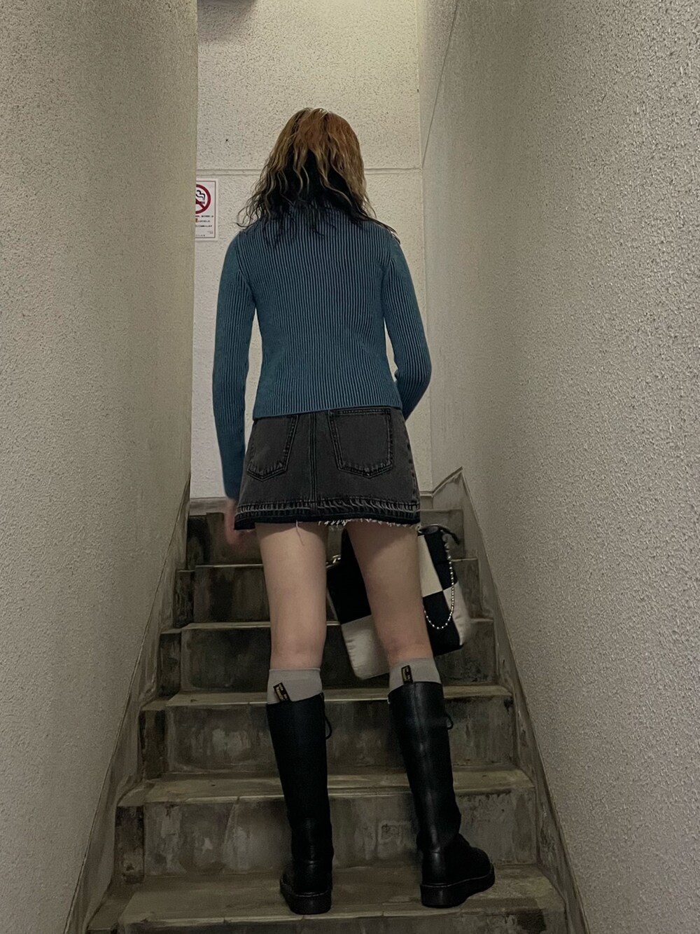 ブルー系のニット/セーター、ブラック系のデニムパンツ、ホワイト系のトートバッグを着用したレディースの秋コーディネートの3枚目の写真