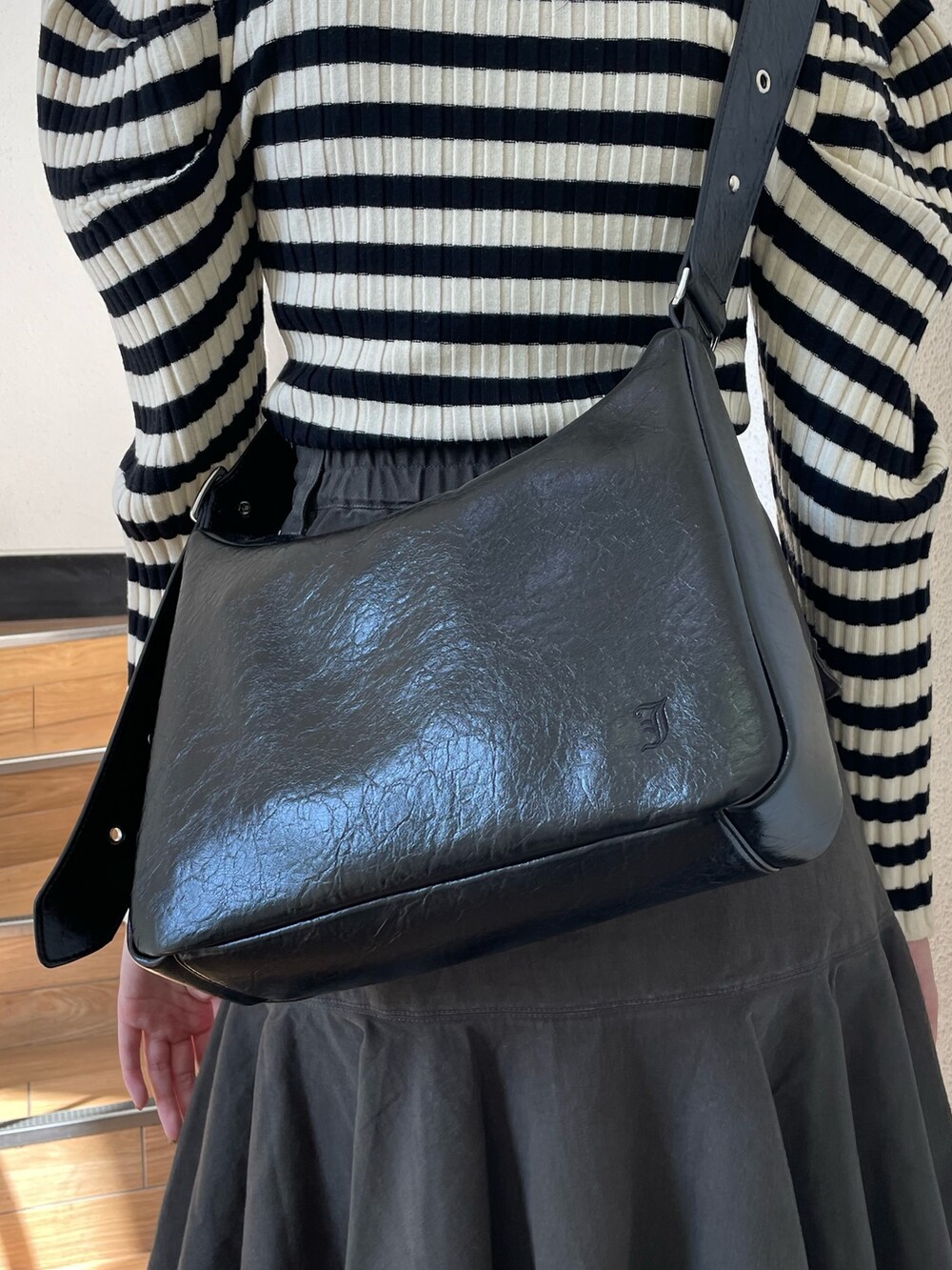 ホワイト系のニット/セーター、ブラック系のブーツ、ブラック系のスカートを着用したレディースの冬コーディネートの8枚目の写真