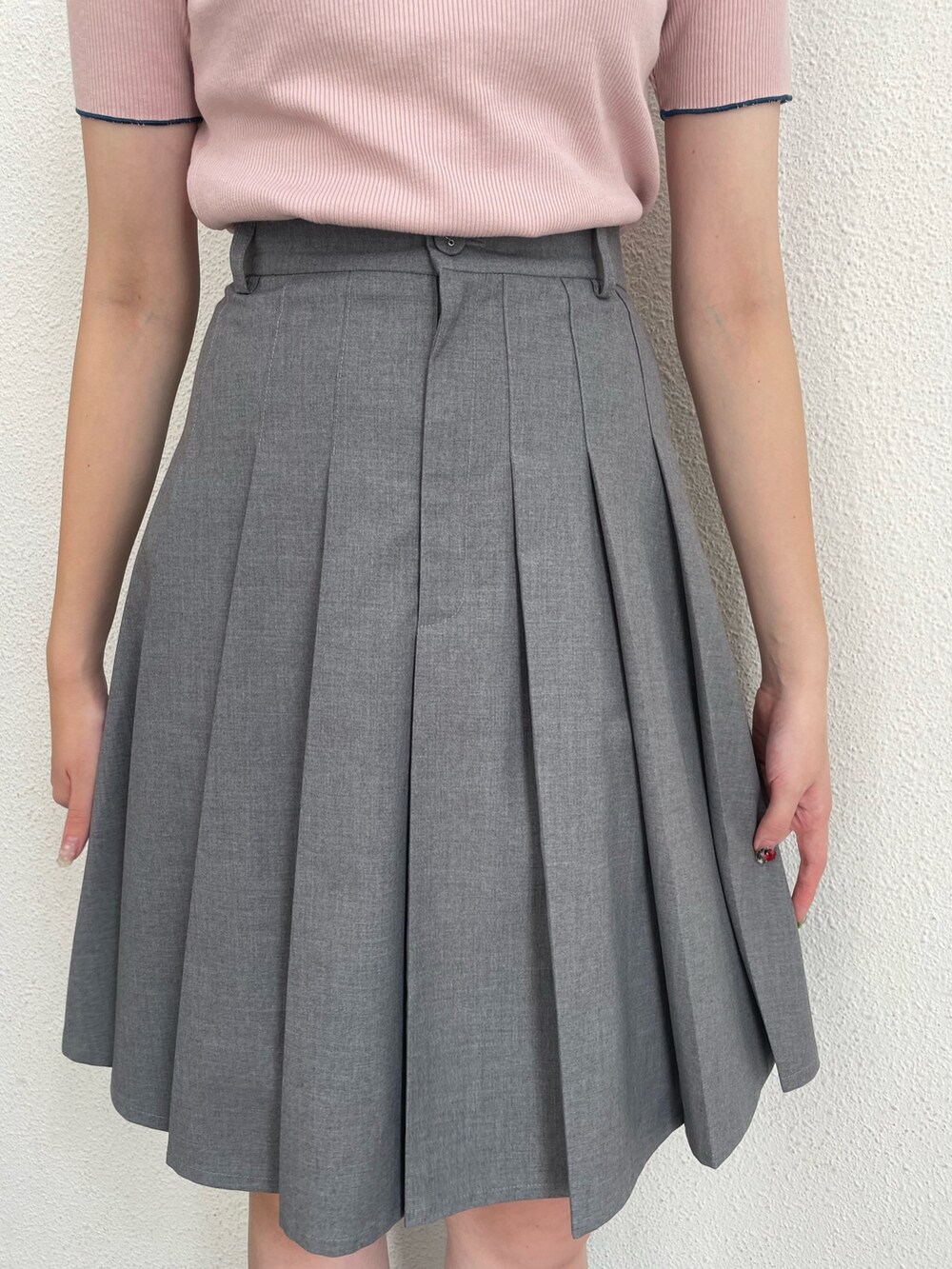 グレー系のスカート、ピンク系のポロシャツ、ブラック系のその他シューズを着用したレディースの春コーディネートの7枚目の写真