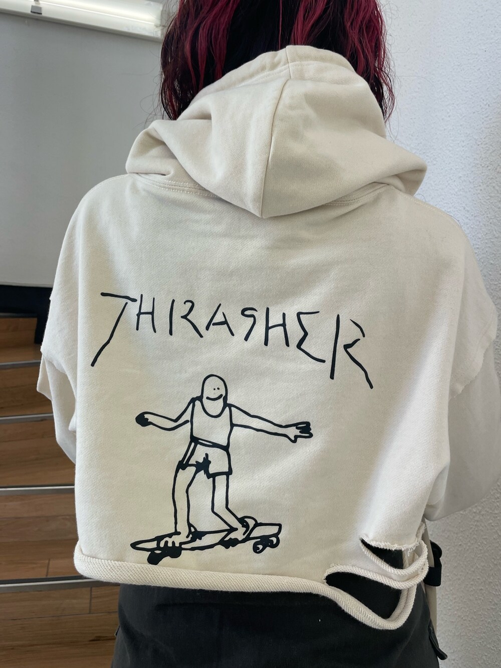 ホワイト系のパーカー、レッド系のブーツ、ブラック系のスカートを着用したレディースの春コーディネートの5枚目の写真