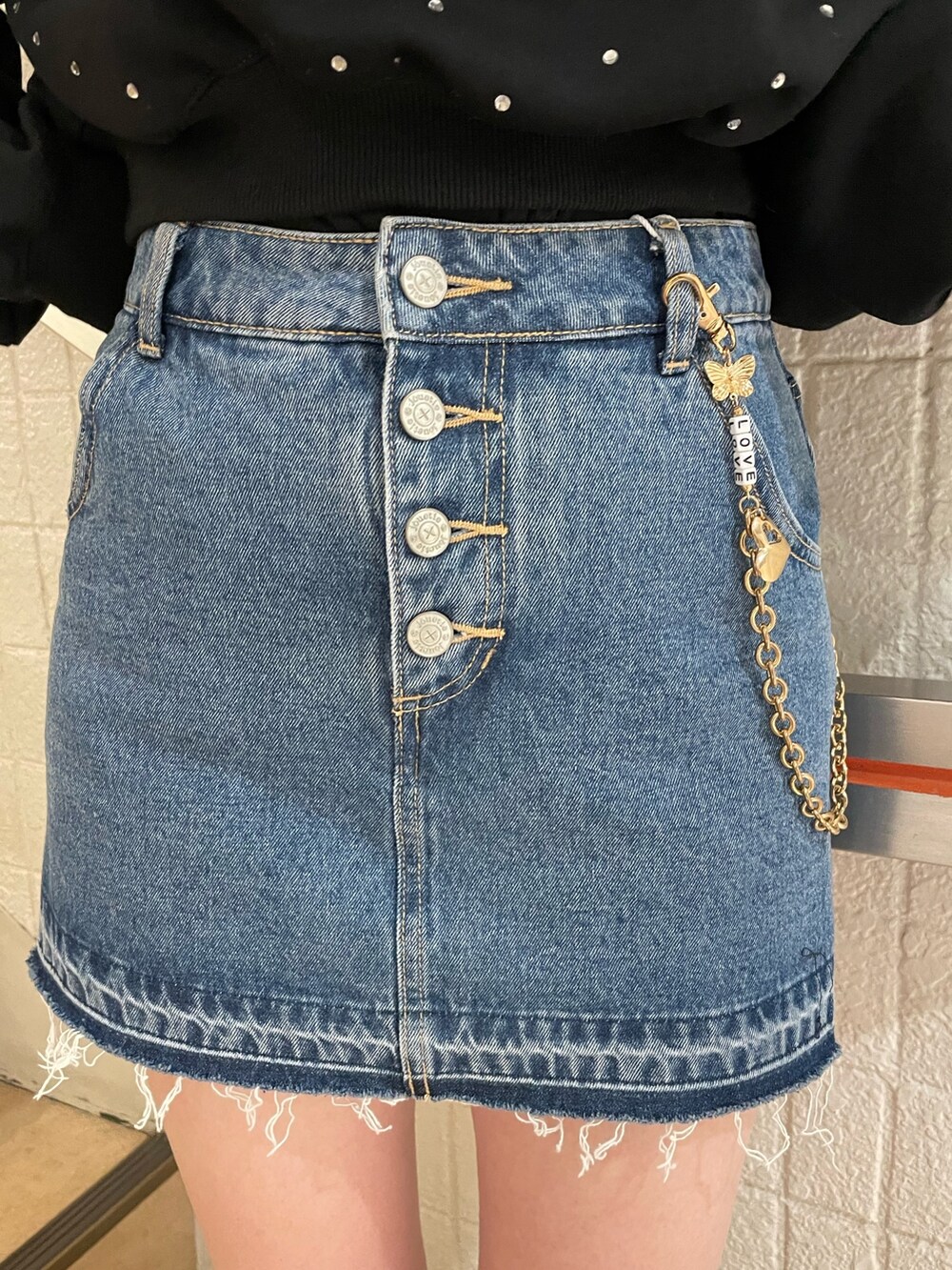 ブラック系のスウェット、ブルー系のデニムパンツ、ブラック系のブーツを着用したレディースの冬コーディネートの7枚目の写真