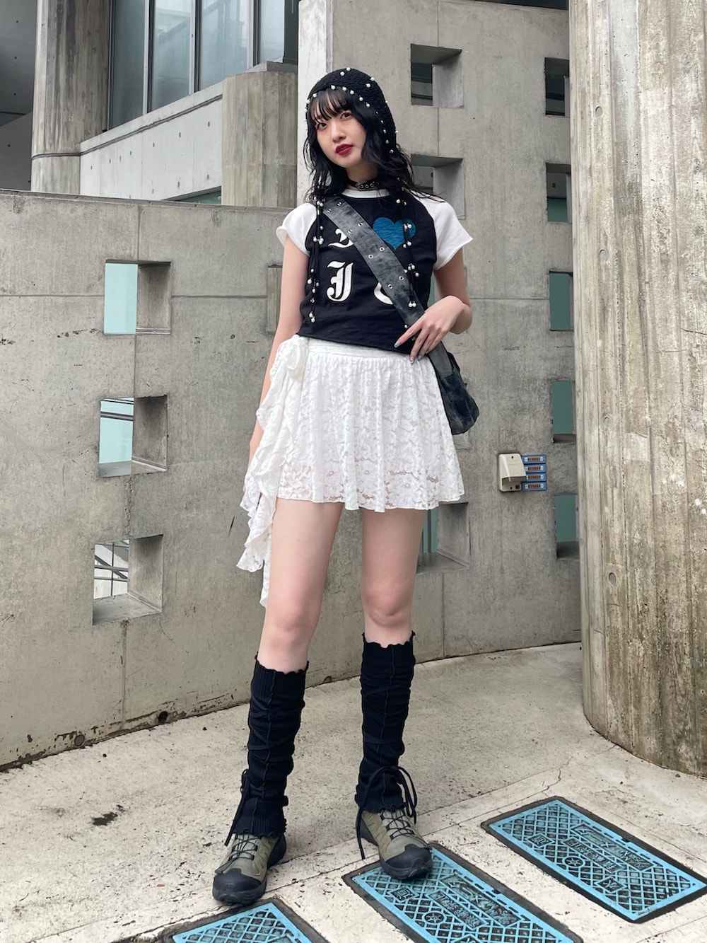 ブラック系のTシャツ/カットソー、ブラック系のメッセンジャーバッグ、ホワイト系のスカートを着用したレディースの春コーディネートの2枚目の写真