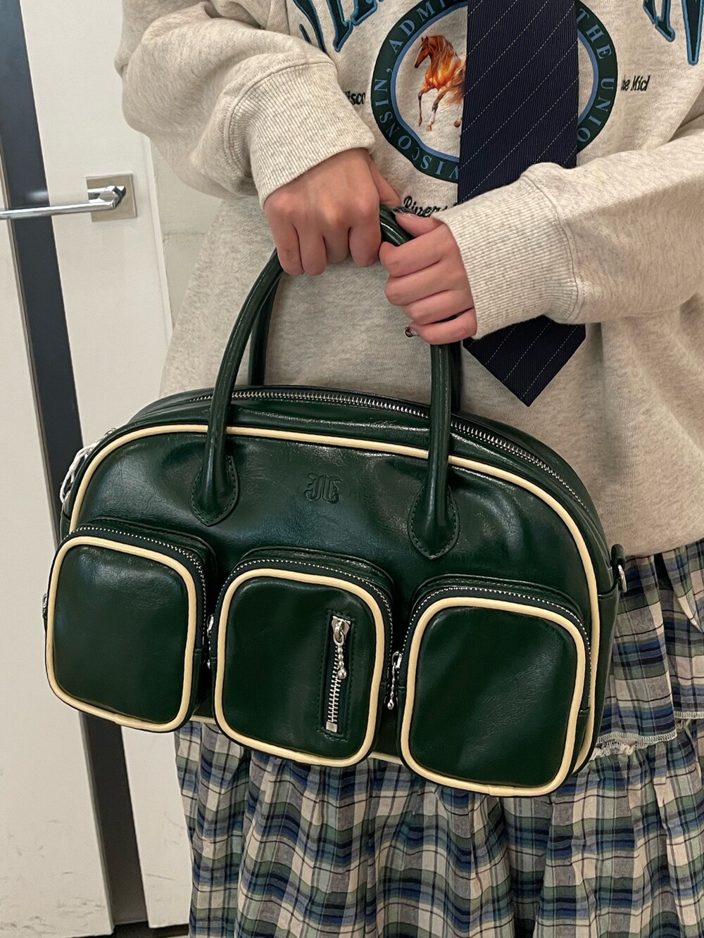 グレー系のスウェット、グリーン系のスカート、グリーン系のボストンバッグを着用したレディースの夏コーディネートの8枚目の写真