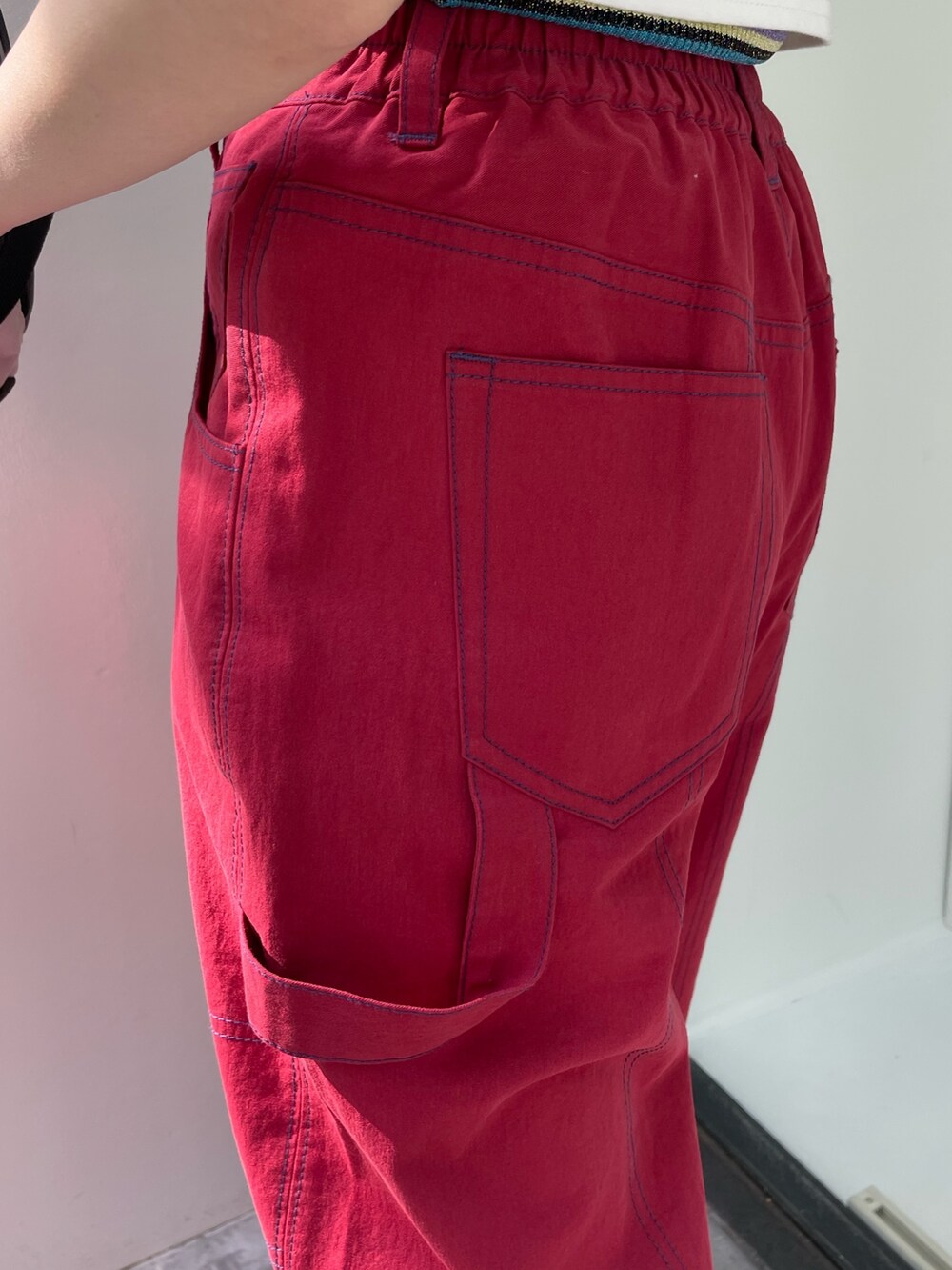 レッド系のその他パンツ、ホワイト系のTシャツ/カットソー、レッド系のサングラスを着用したレディースの春コーディネートの8枚目の写真