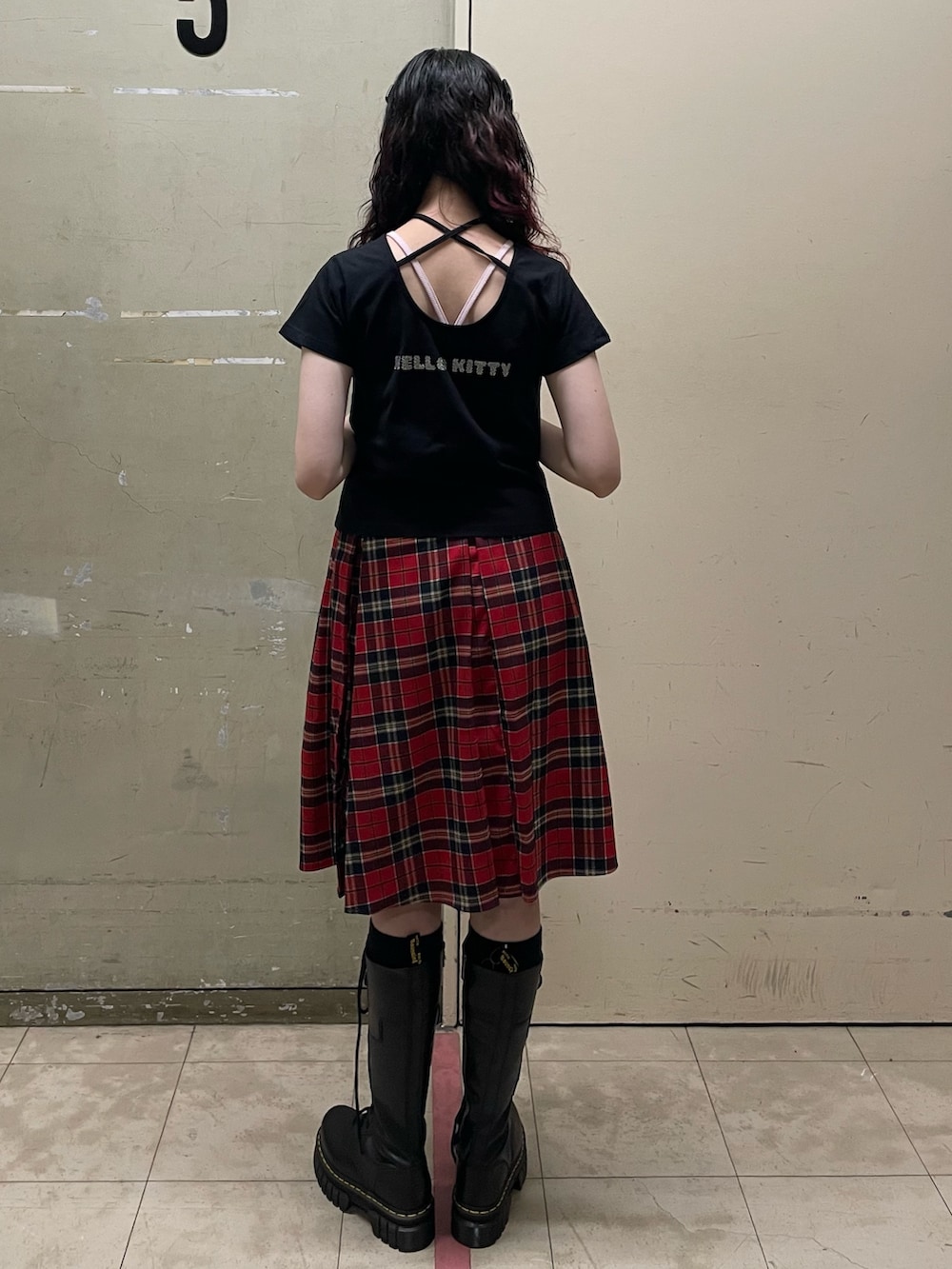 ブラック系のTシャツ/カットソー、レッド系のスカート、ブラック系のブーツを着用したレディースの春コーディネートの4枚目の写真