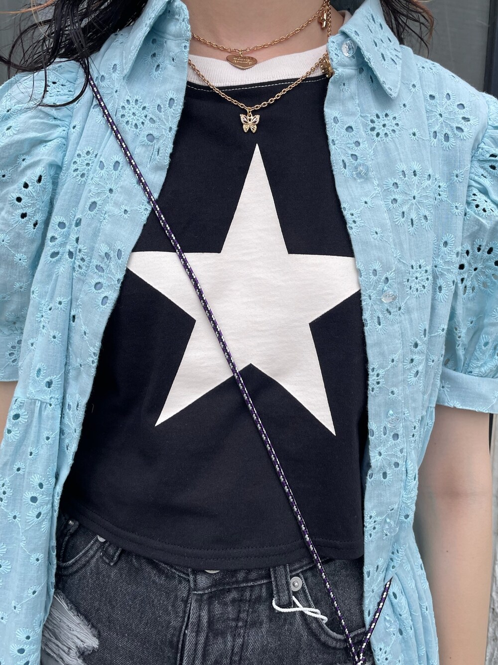 ブルー系のワンピース、ブラック系のショルダーバッグ、ブラック系のデニムパンツを着用したレディースの夏コーディネートの5枚目の写真