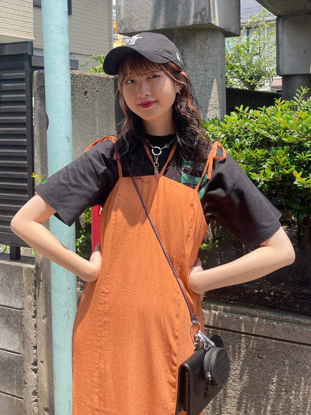 ブラック系のTシャツ/カットソー、オレンジ系のワンピース、ブラック系のショルダーバッグを着用したレディースの夏コーディネートの4枚目の写真
