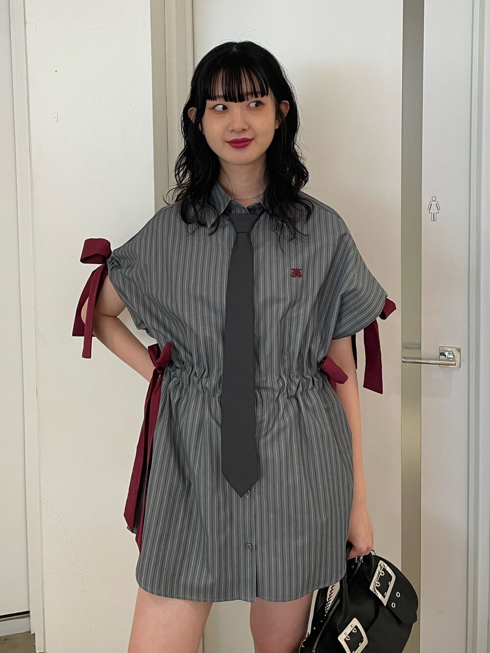 グレー系のシャツ/ブラウス、グレー系のネクタイ、ブラック系のボストンバッグを着用したレディースの夏コーディネートの3枚目の写真