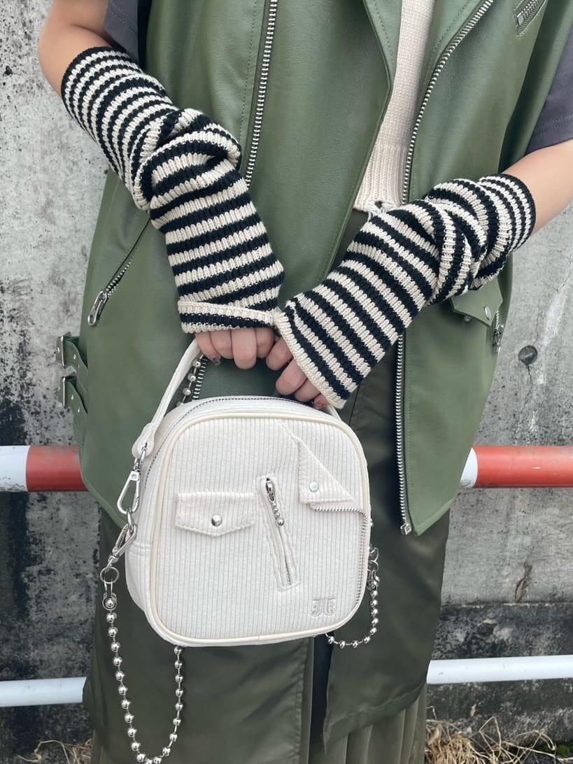 ブラック系のブーツ、ベージュ系のスカート、ホワイト系のベストを着用したレディースの秋コーディネートの7枚目の写真