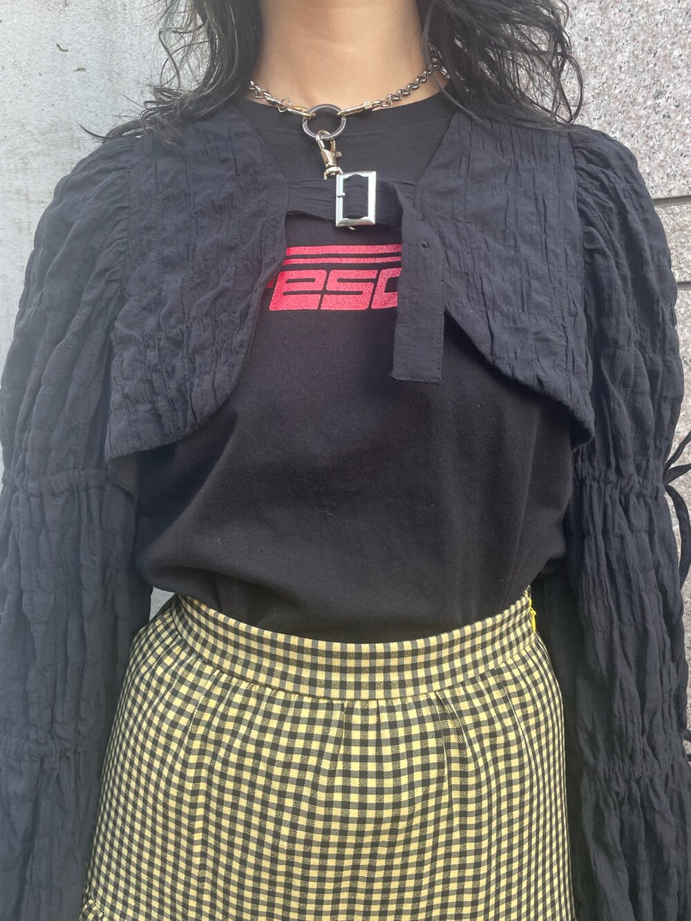 イエロー系のスカート、ブラック系のカーディガン/ボレロ、ブラック系のTシャツ/カットソーを着用したレディースの春コーディネートの5枚目の写真