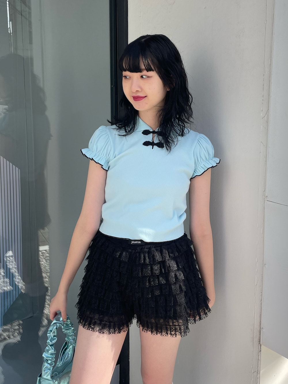 ブルー系のポロシャツ、ブラック系のその他パンツ、ブルー系のハンドバッグを着用したレディースの冬コーディネートの5枚目の写真