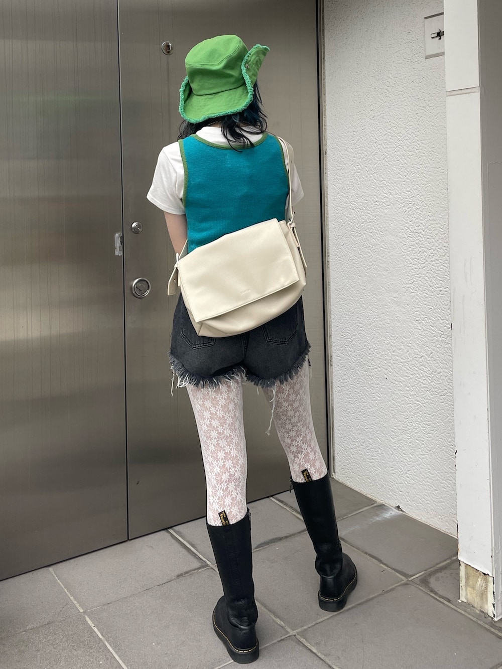 ブラック系のデニムパンツ、ブルー系のタンクトップ、ホワイト系のTシャツ/カットソーを着用したレディースの春コーディネートの3枚目の写真