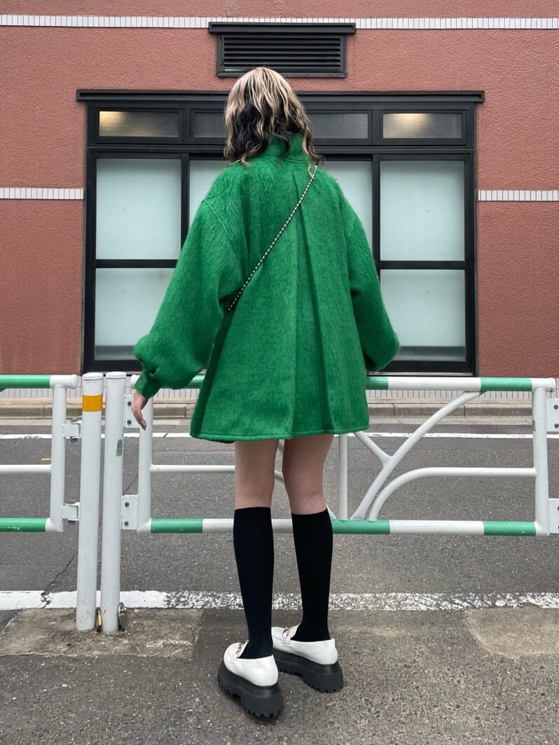 ホワイト系のローファー、グリーン系のその他アウター、ホワイト系のハンドバッグを着用したレディースの秋コーディネートの3枚目の写真