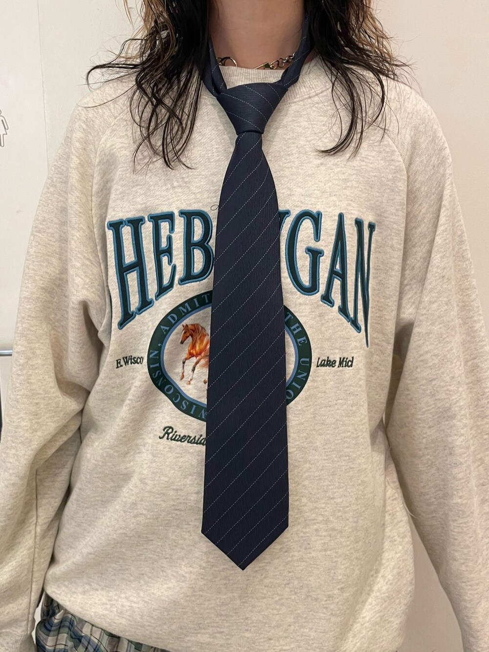 グレー系のスウェット、グリーン系のスカート、グリーン系のボストンバッグを着用したレディースの夏コーディネートの5枚目の写真