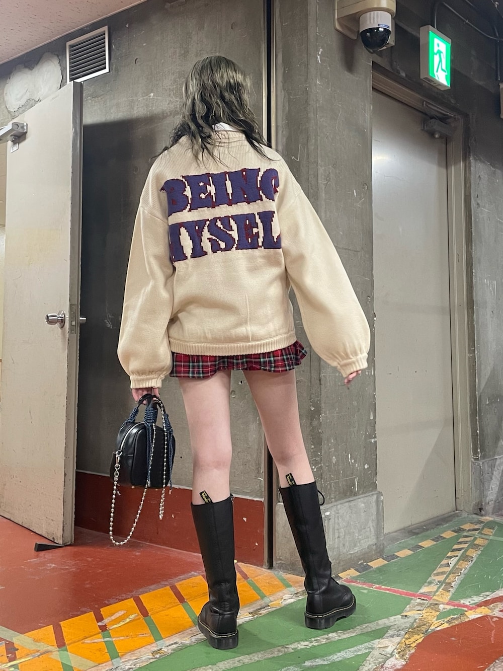 レッド系のその他パンツ、ブラック系のショルダーバッグ、ブラック系のブーツを着用したレディースの冬コーディネートの3枚目の写真