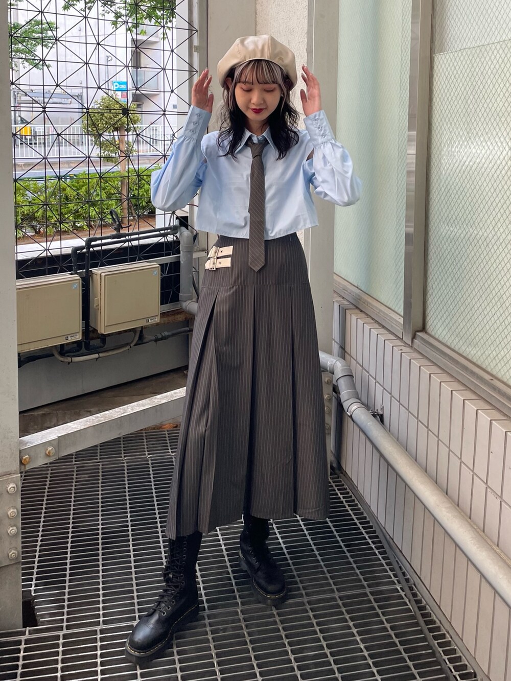 グレー系のスカート、ブルー系のシャツ/ブラウス、ブラック系のブーツを着用したレディースの春コーディネートの2枚目の写真