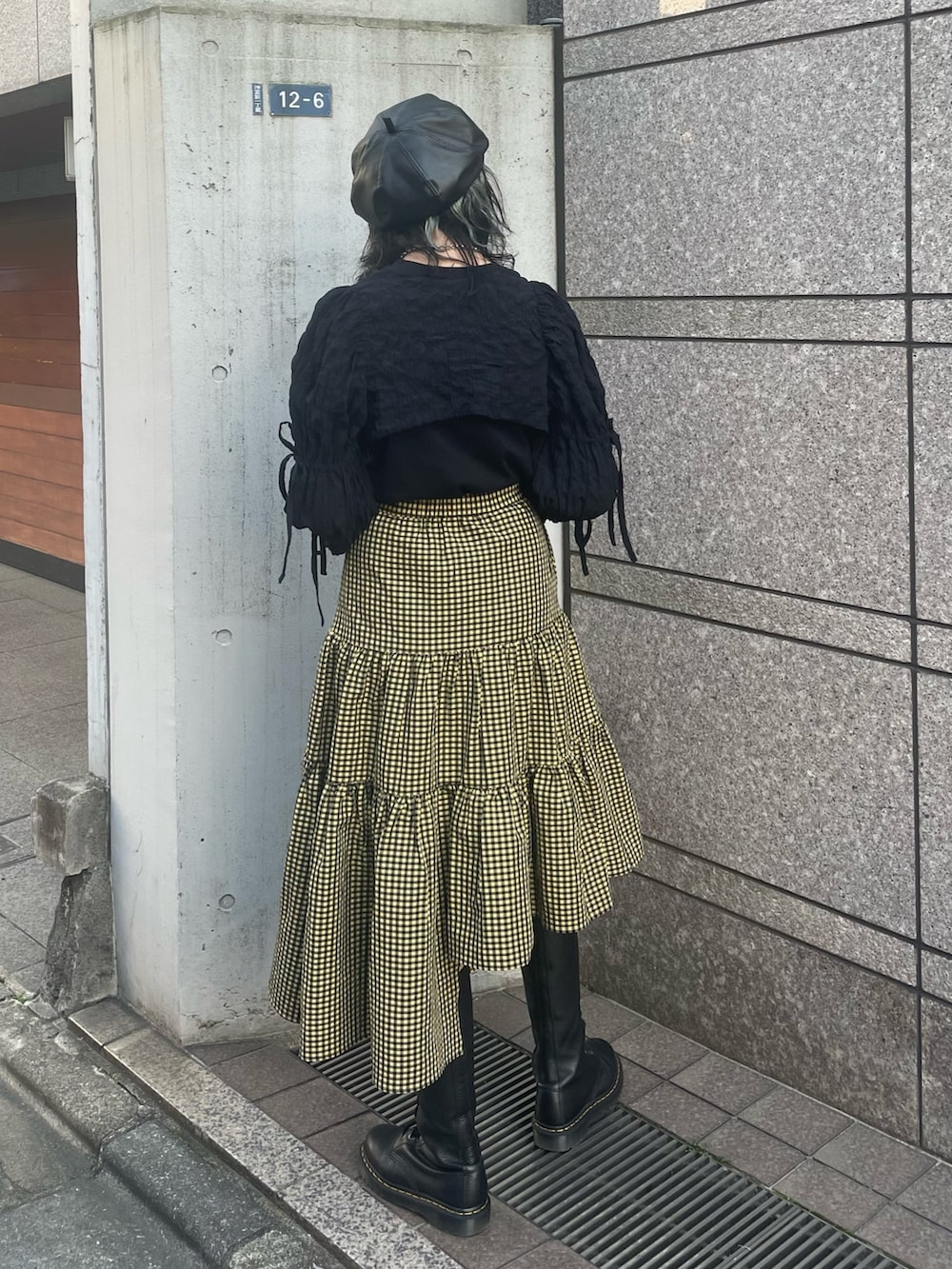 イエロー系のスカート、ブラック系のカーディガン/ボレロ、ブラック系のTシャツ/カットソーを着用したレディースの春コーディネートの3枚目の写真