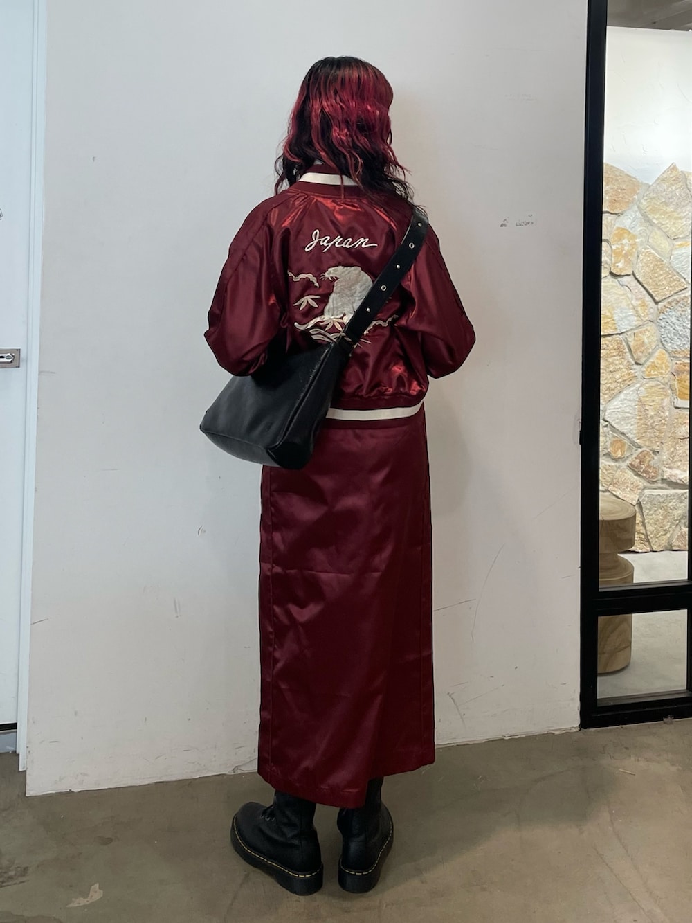 ホワイト系のニット/セーター、レッド系のスカジャン、レッド系のスカートを着用したレディースの春コーディネートの3枚目の写真