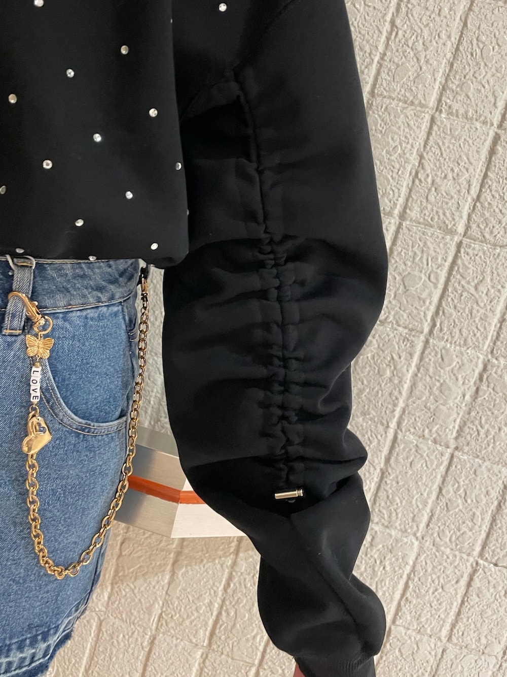 ブラック系のスウェット、ブルー系のデニムパンツ、ブラック系のブーツを着用したレディースの冬コーディネートの6枚目の写真