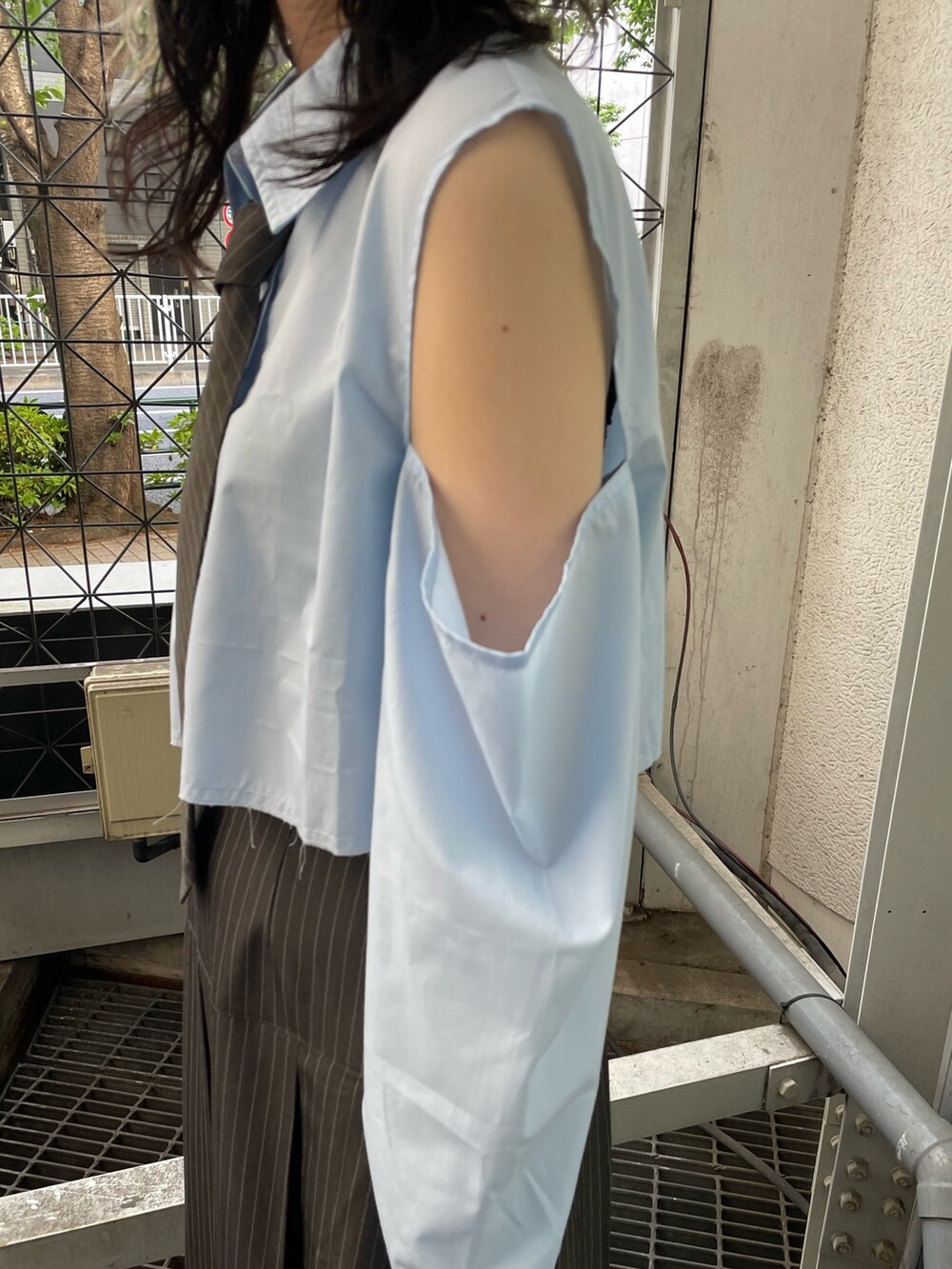 グレー系のスカート、ブルー系のシャツ/ブラウス、ブラック系のブーツを着用したレディースの春コーディネートの7枚目の写真