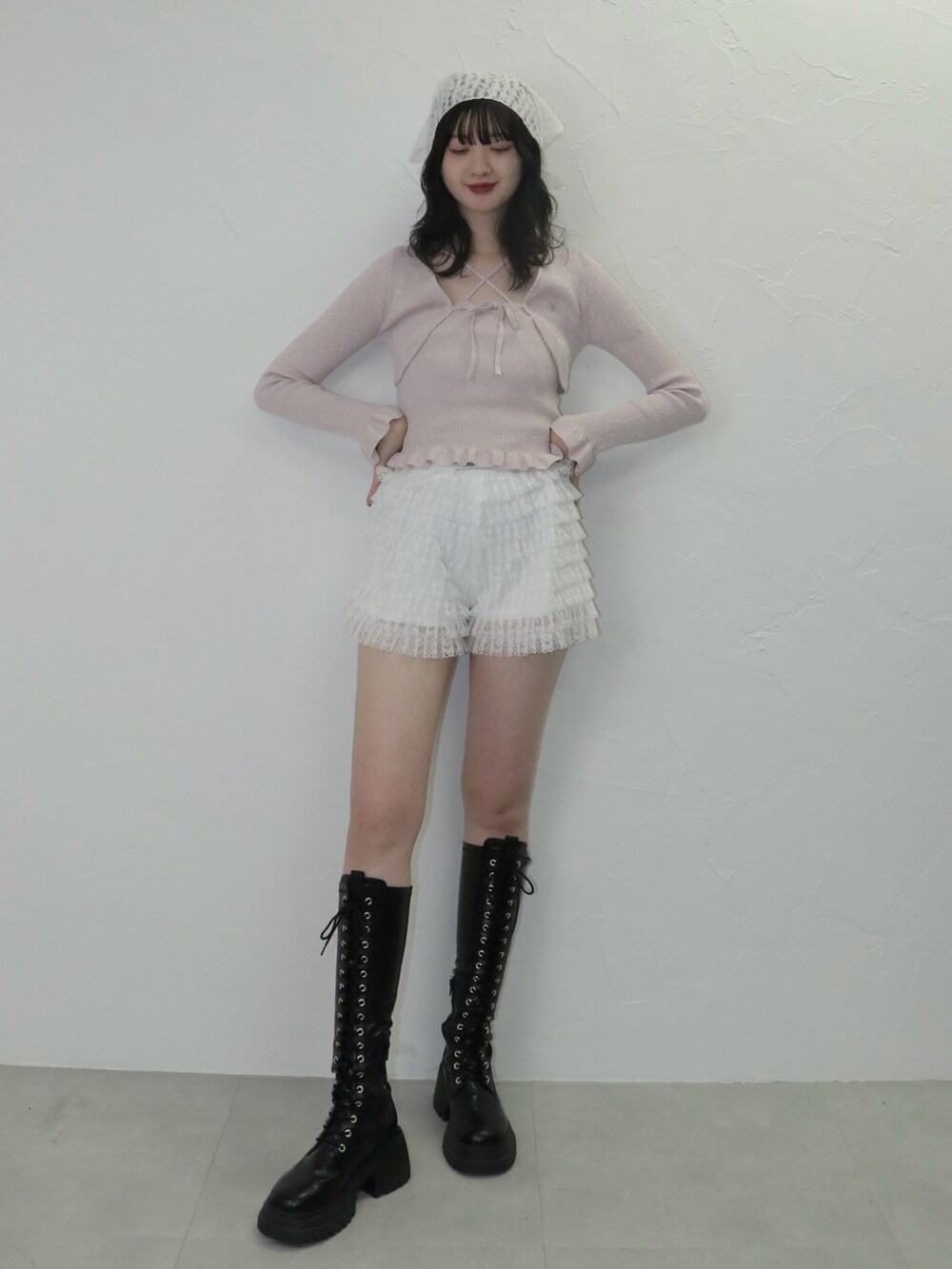 ピンク系のアンサンブル、ホワイト系のその他パンツ、ブラック系のブーツを着用したレディースの冬コーディネートの2枚目の写真