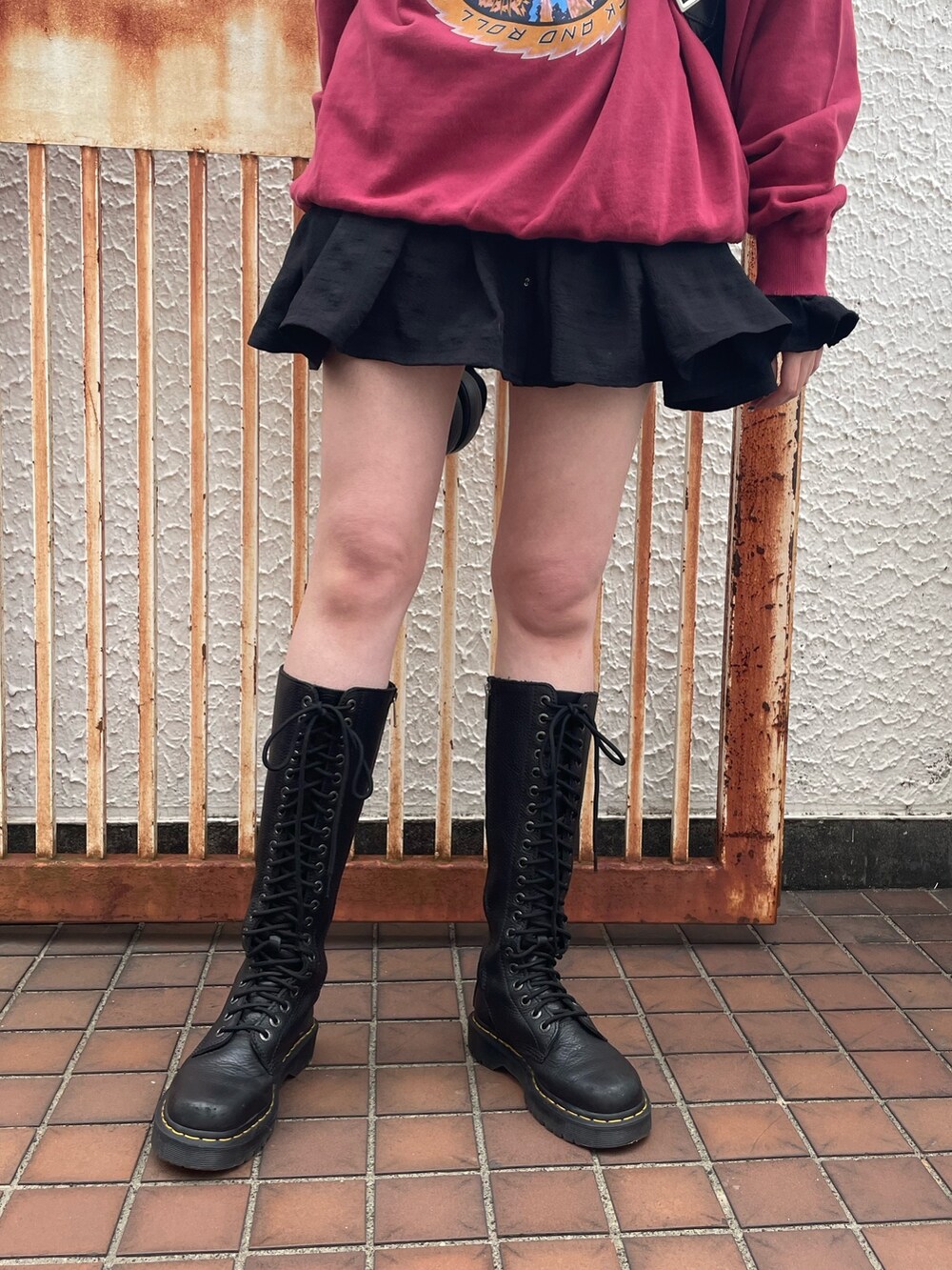 レッド系のスウェット、ブラック系のシャツ/ブラウス、ブラック系のハンドバッグを着用したレディースの冬コーディネートの6枚目の写真