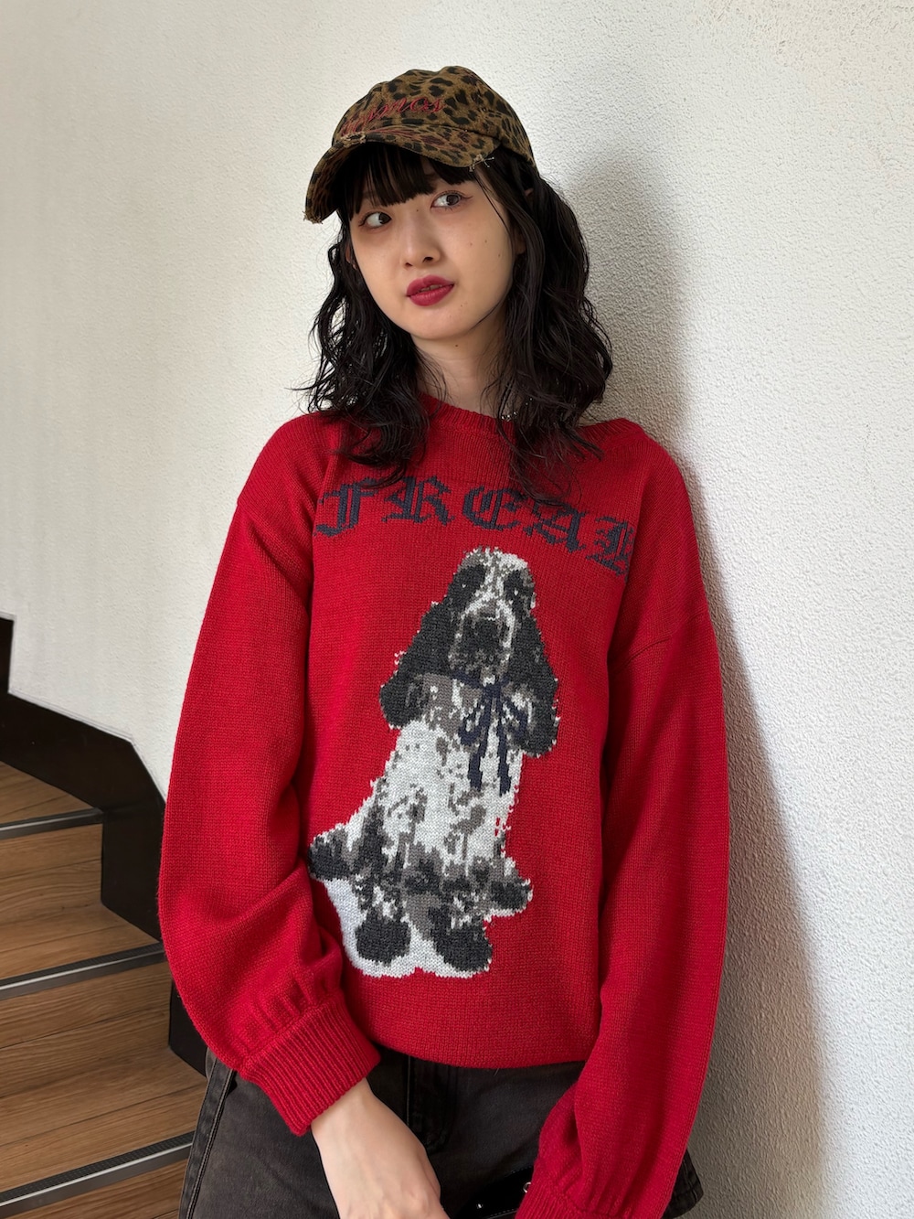 レッド系のニット/セーター、ブラック系のデニムパンツ、ブラック系のショルダーバッグを着用したレディースの秋コーディネートの4枚目の写真