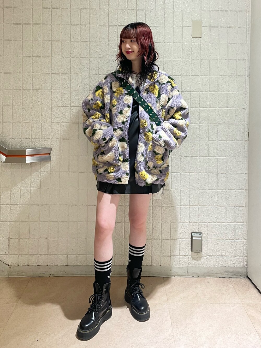 パープル系のブルゾン、ホワイト系のニット/セーター、ブラック系のジャンパースカートを着用したレディースの秋コーディネートの2枚目の写真