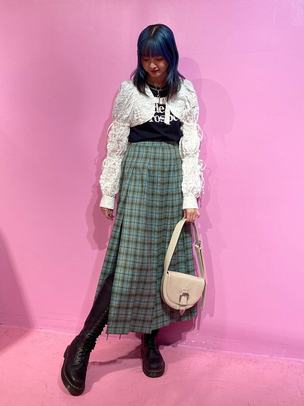 ブラック系のTシャツ/カットソー、ホワイト系のカーディガン/ボレロ、グリーン系のスカートを着用したレディースの冬コーディネートの2枚目の写真