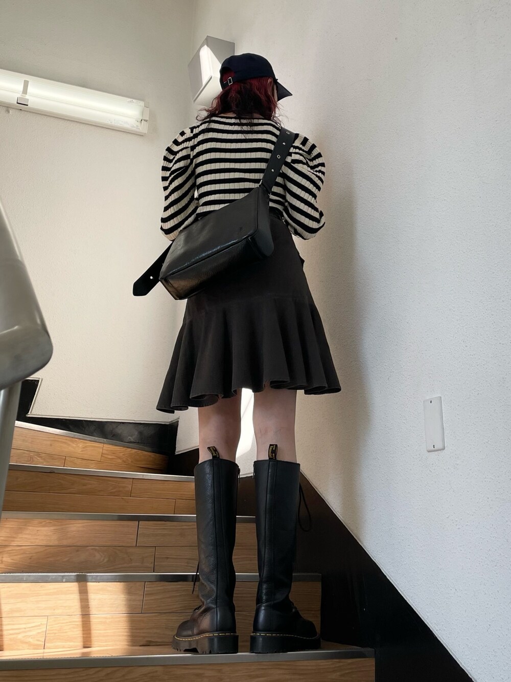 ホワイト系のニット/セーター、ブラック系のブーツ、ブラック系のスカートを着用したレディースの冬コーディネートの3枚目の写真