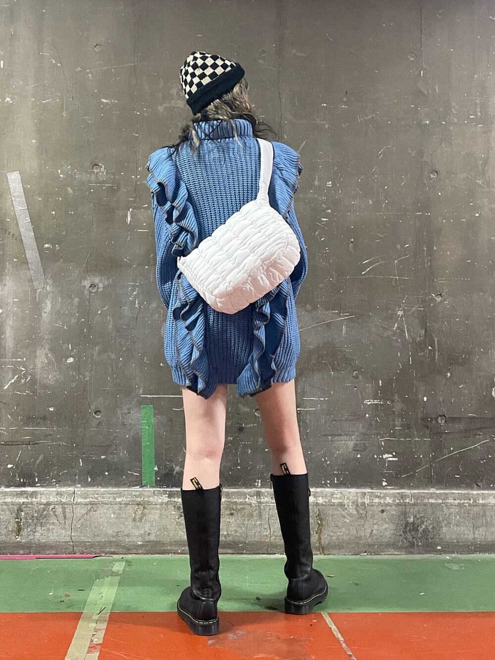 ブラック系のブーツ、ホワイト系のハンドバッグ、ブルー系のニット/セーターを着用したレディースの冬コーディネートの3枚目の写真