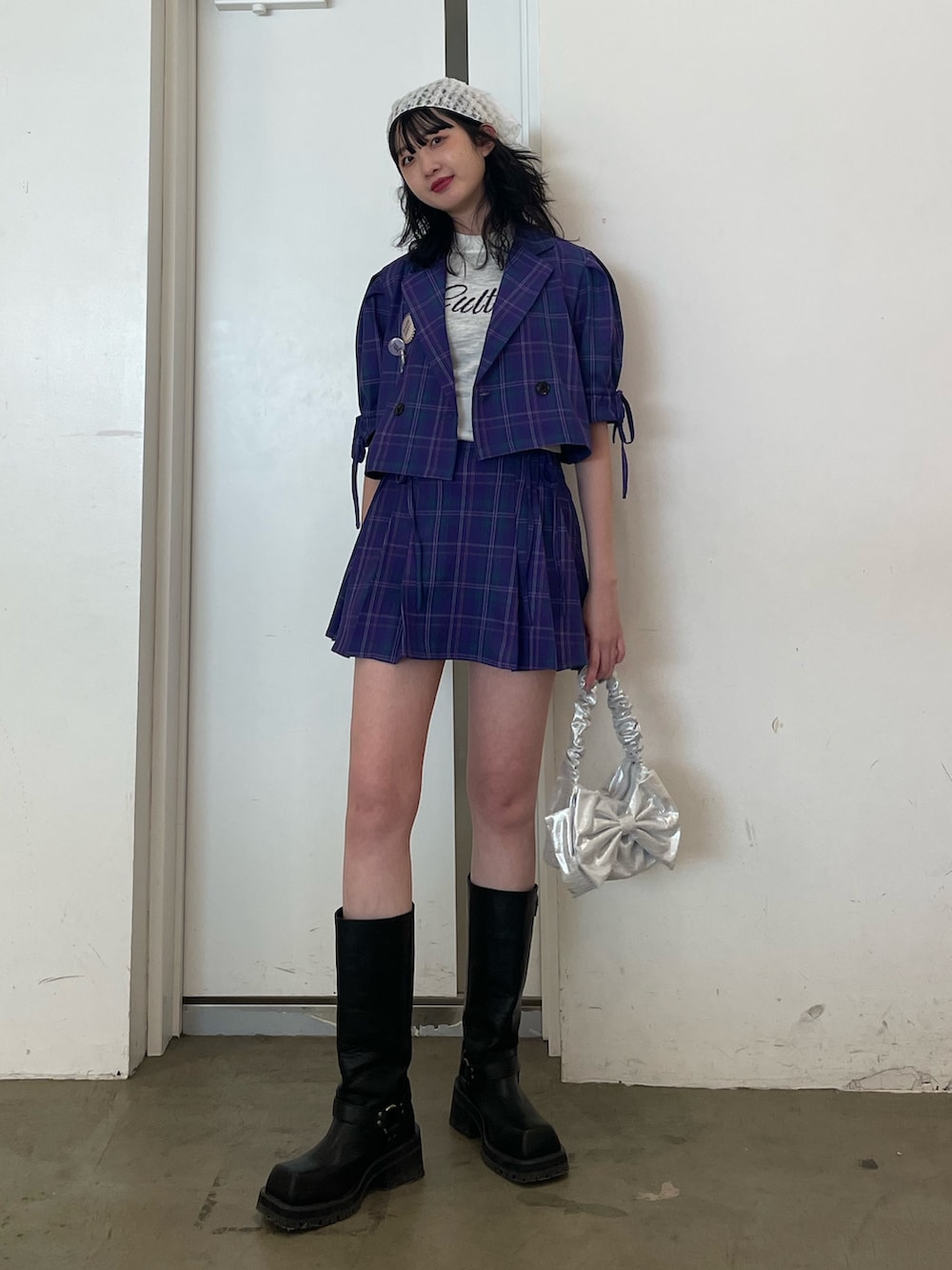 ホワイト系のニット/セーター、パープル系のテーラードジャケット、パープル系のスカートを着用したレディースの冬コーディネートの2枚目の写真