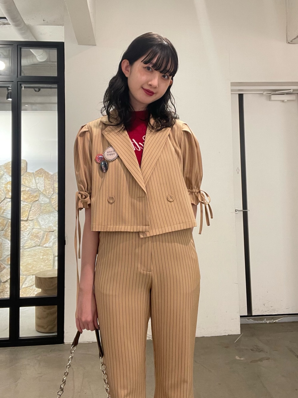 ベージュ系のその他パンツ、ベージュ系のテーラードジャケット、レッド系のニット/セーターを着用したレディースの冬コーディネートの4枚目の写真