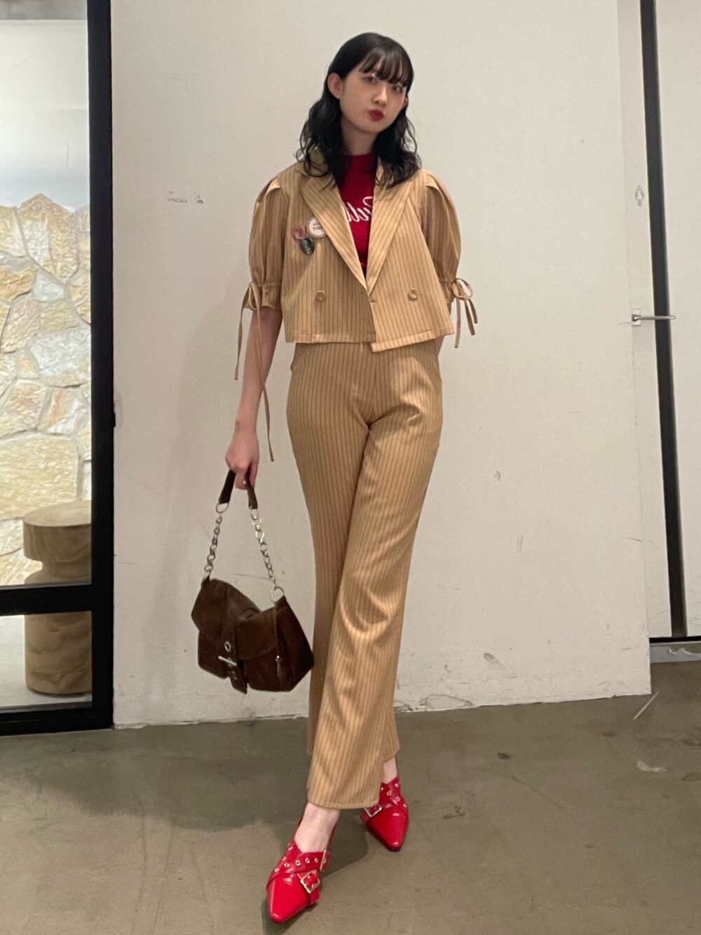 ベージュ系のその他パンツ、ベージュ系のテーラードジャケット、レッド系のニット/セーターを着用したレディースの冬コーディネートの2枚目の写真