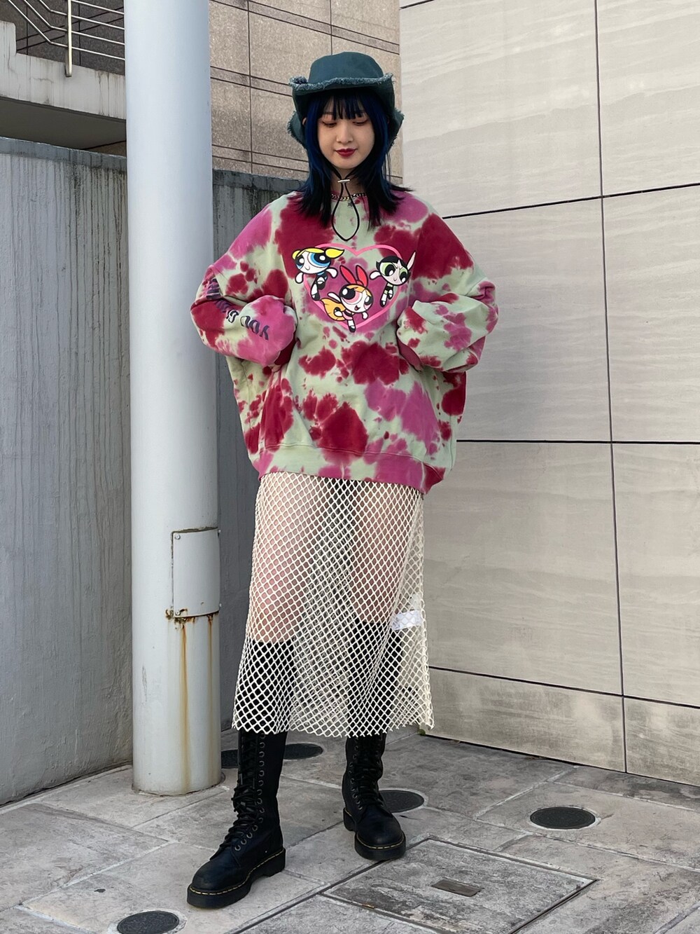 グリーン系のスウェット、ホワイト系のワンピース、ブラック系のブーツを着用したレディースの冬コーディネートの2枚目の写真