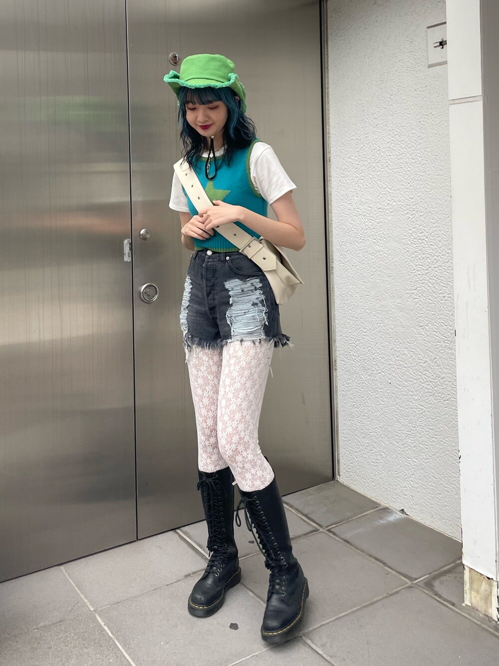 ブラック系のデニムパンツ、ブルー系のタンクトップ、ホワイト系のTシャツ/カットソーを着用したレディースの春コーディネートの2枚目の写真