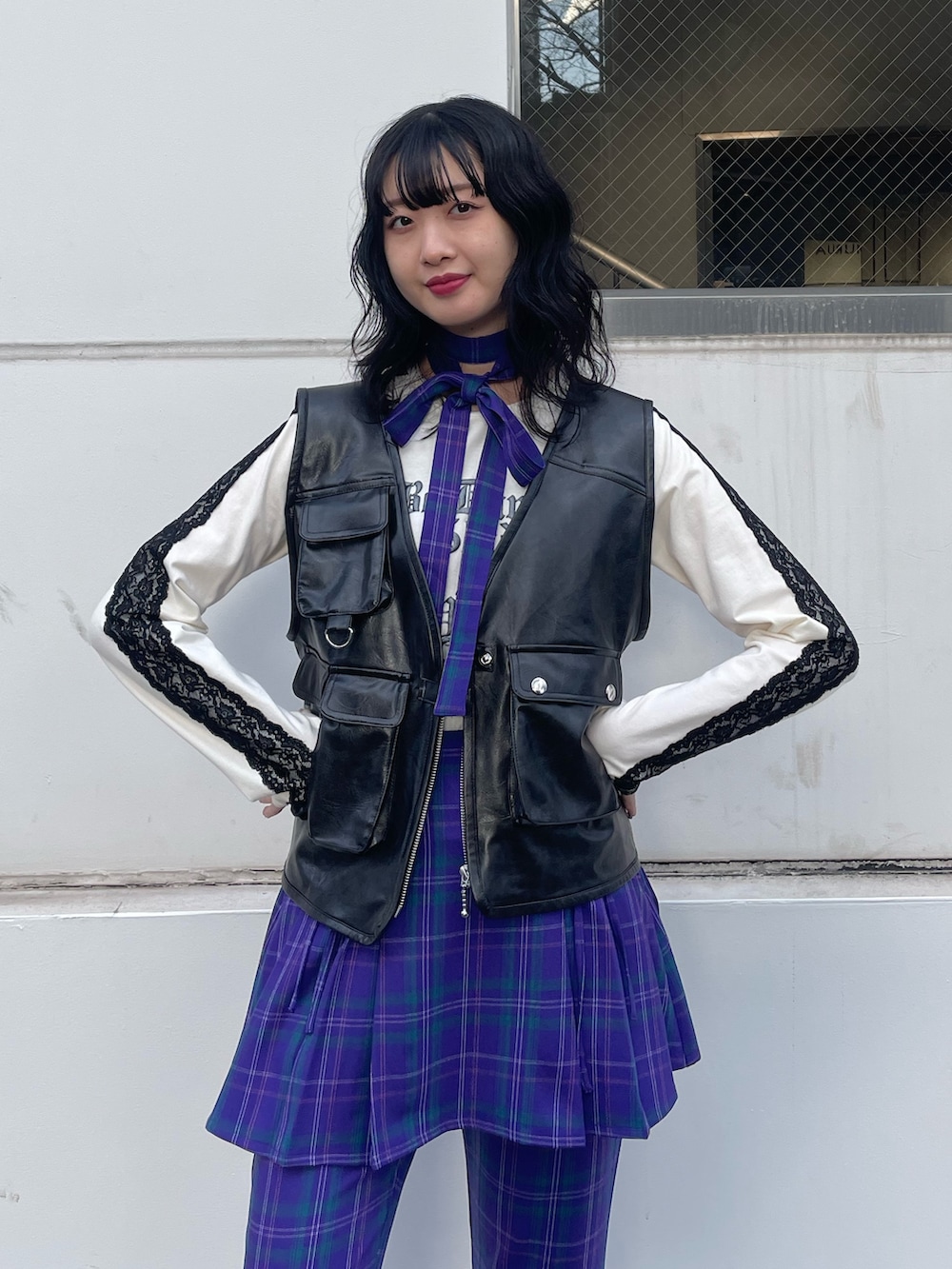 ブラック系のスニーカー、ブラック系のベスト、ホワイト系のTシャツ/カットソーを着用したレディースの冬コーディネートの5枚目の写真