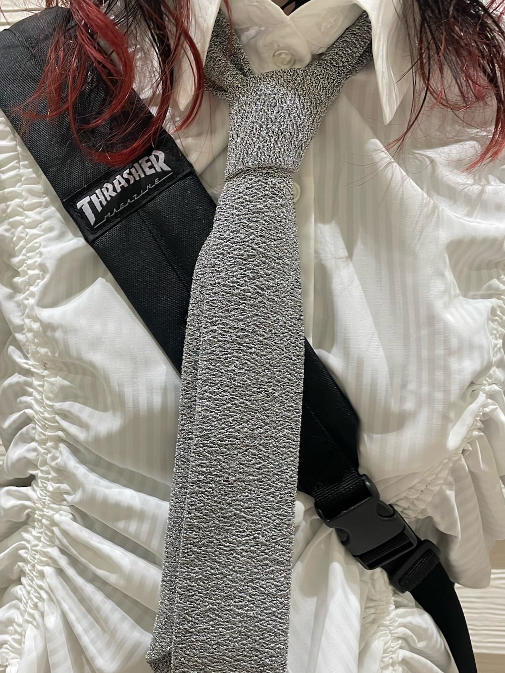 ブラック系のバックパック/リュック、シルバー系のネクタイ、ホワイト系のシャツ/ブラウスを着用したレディースの春コーディネートの5枚目の写真