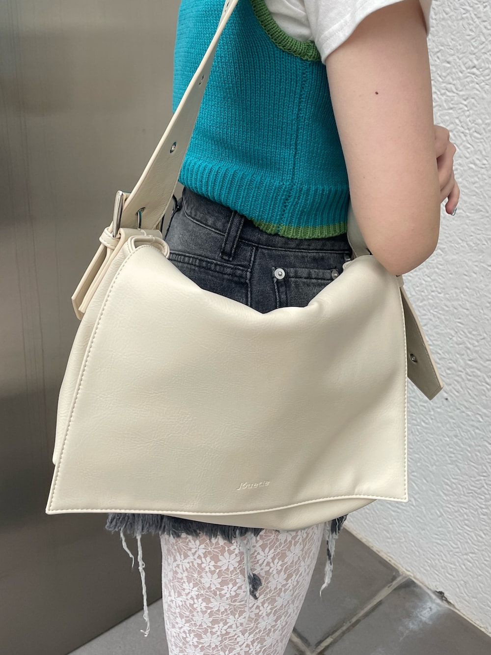 ブラック系のデニムパンツ、ブルー系のタンクトップ、ホワイト系のTシャツ/カットソーを着用したレディースの春コーディネートの6枚目の写真