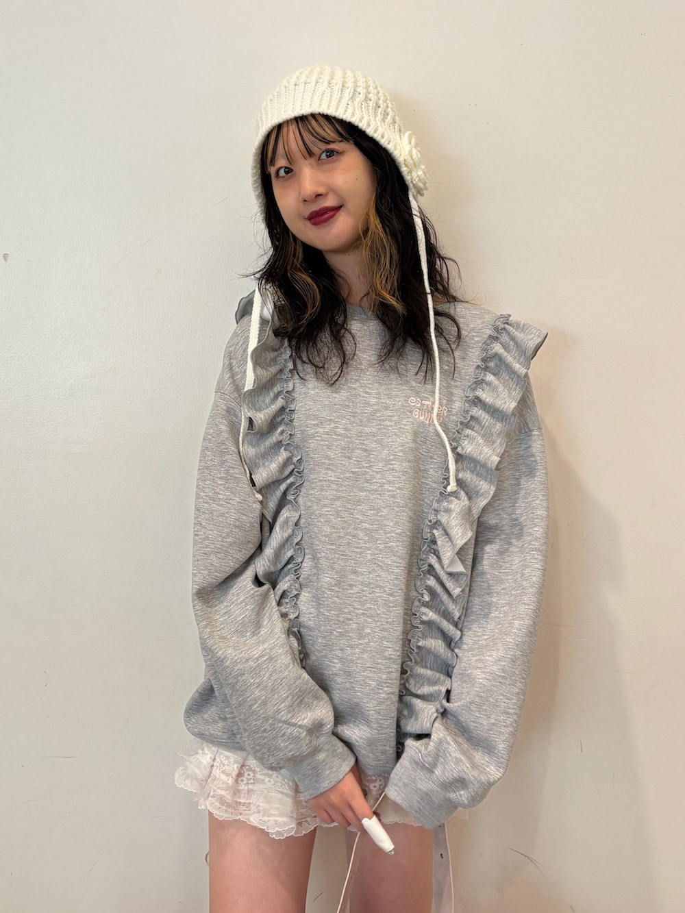 グレー系のスウェット、ピンク系のショルダーバッグ、ブラウン系のブーツを着用したレディースの秋コーディネートの3枚目の写真