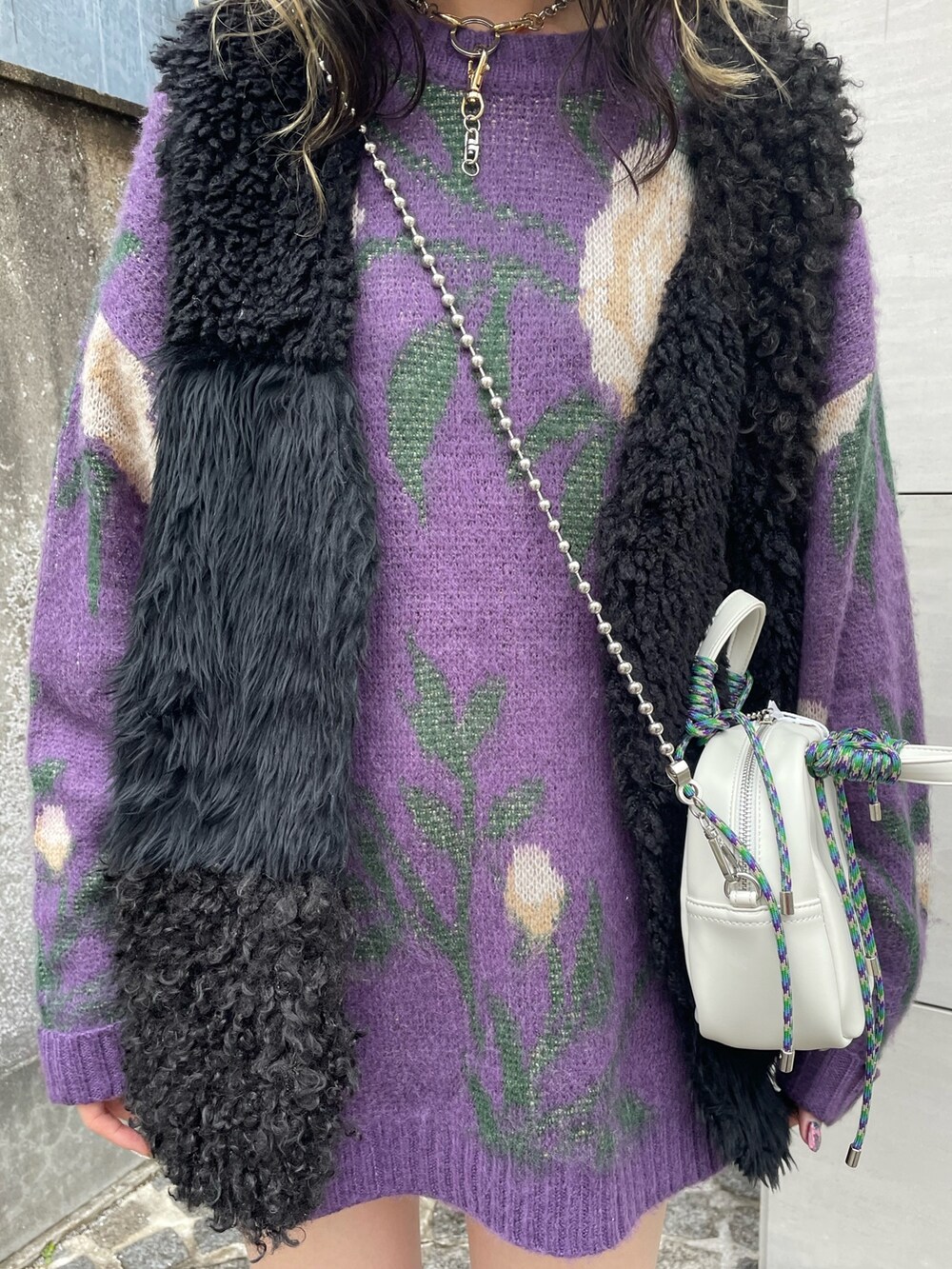 パープル系のニット/セーター、ホワイト系のショルダーバッグ、ブラック系のベストを着用したレディースの冬コーディネートの5枚目の写真