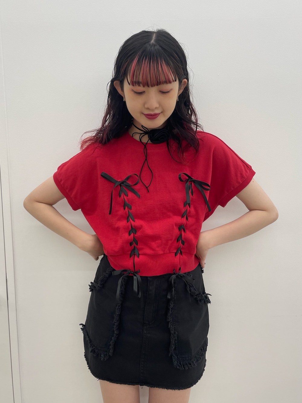 レッド系のTシャツ/カットソー、ブラック系のスカート、ブラック系のブーツを着用したレディースの夏コーディネートの4枚目の写真