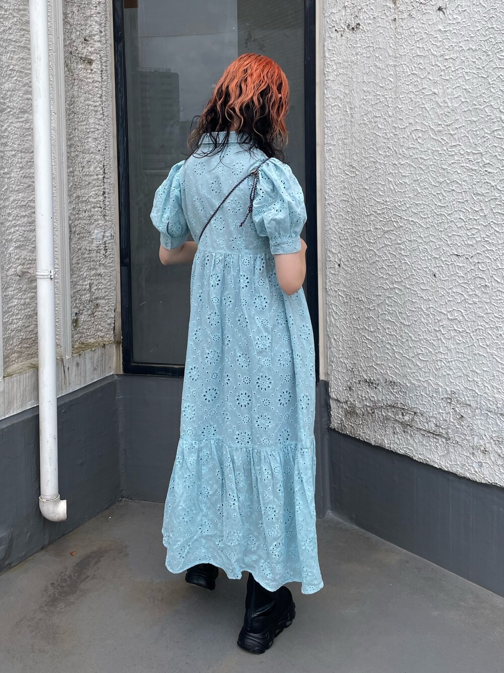 ブルー系のワンピース、ブラック系のショルダーバッグ、ブラック系のデニムパンツを着用したレディースの夏コーディネートの3枚目の写真