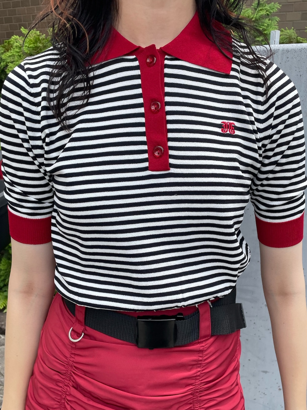 ホワイト系のニット/セーター、ブラック系のボストンバッグ、レッド系のスカートを着用したレディースの夏コーディネートの5枚目の写真