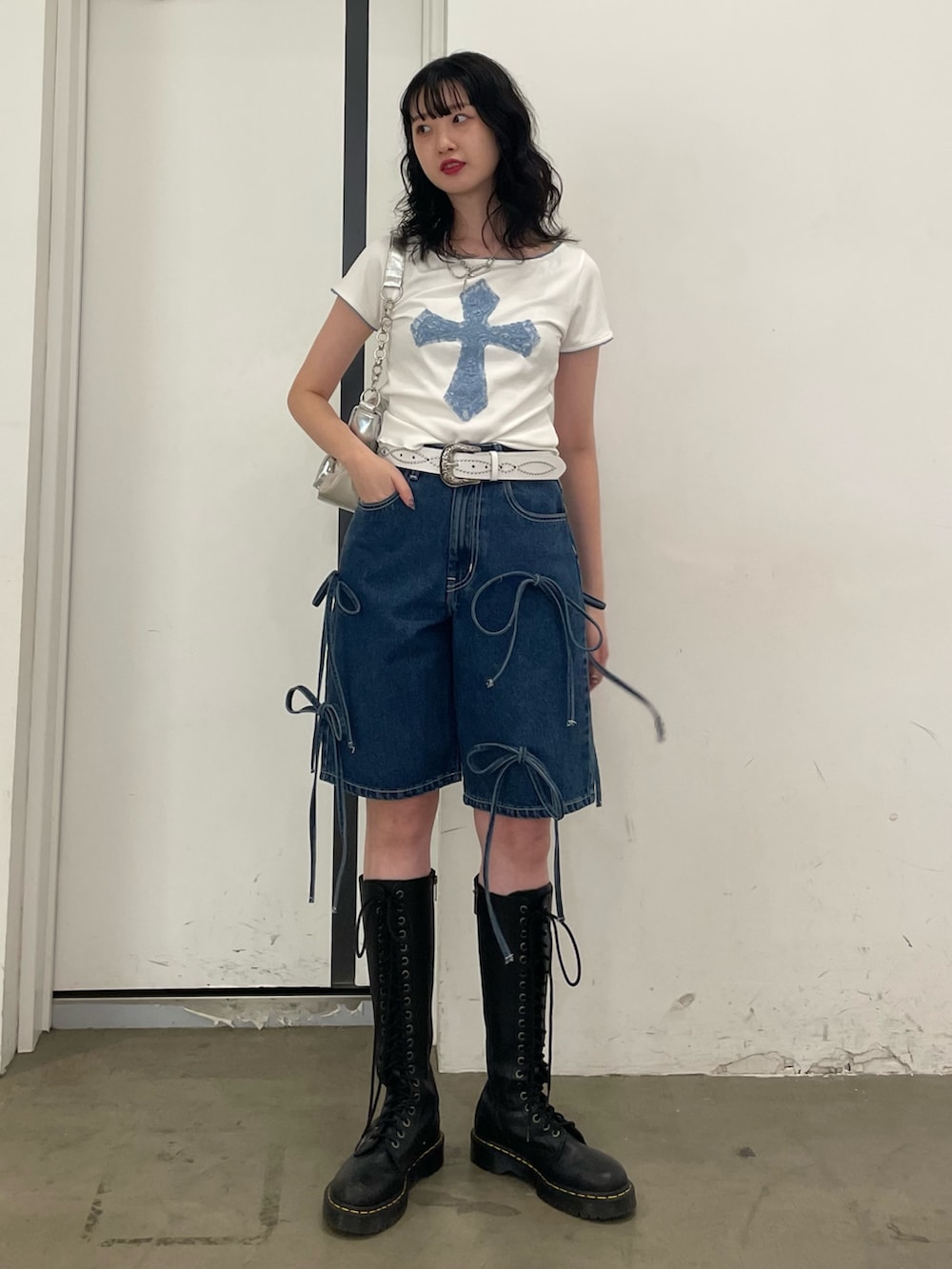 ホワイト系のTシャツ/カットソー、シルバー系のハンドバッグ、ブルー系のデニムパンツを着用したレディースの春コーディネートの2枚目の写真